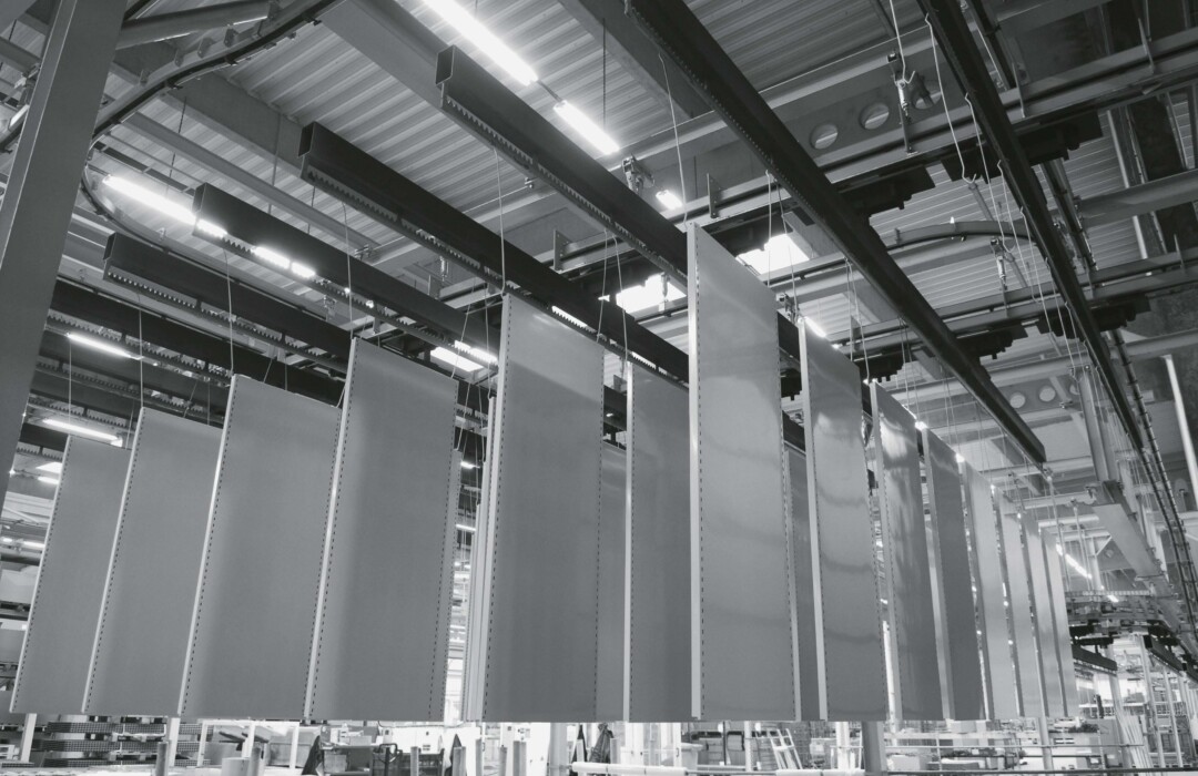 Industrial warehouse with tall white shelving units and overhead lighting