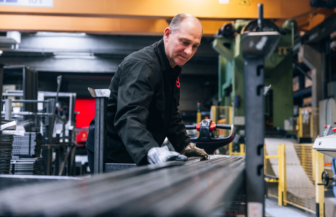 Factory worker assembling retail shelving or display unit at Gondella manufacturing facility