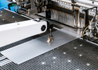 Custom metal fabrication workstation with perforated steel plate and precision machining equipment