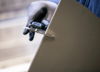 Custom metal bracket being measured during fabrication for retail shelving installation