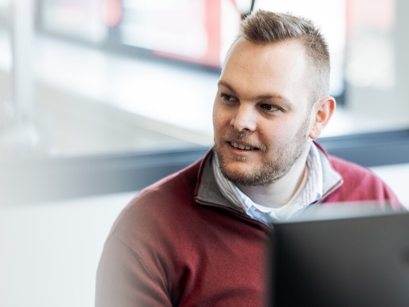 Gondella team member reviewing retail solutions on laptop in modern office environment