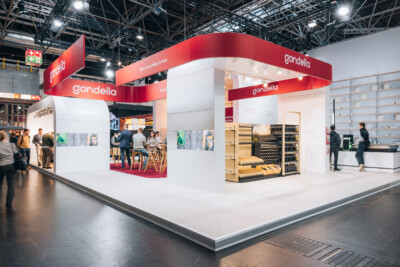 Gondella exhibition stand at Euroshop Düsseldorf 2023 featuring red branding, product displays, and retail shelving solutions