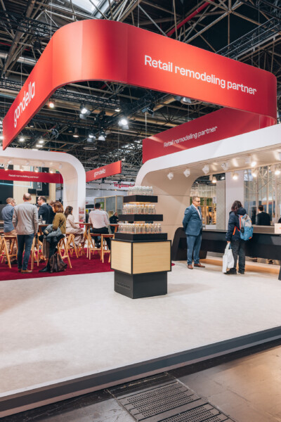 Gondella retail remodeling partner exhibition booth at EuroShop 2023 with red branding, shelving displays, and visitor engagement area