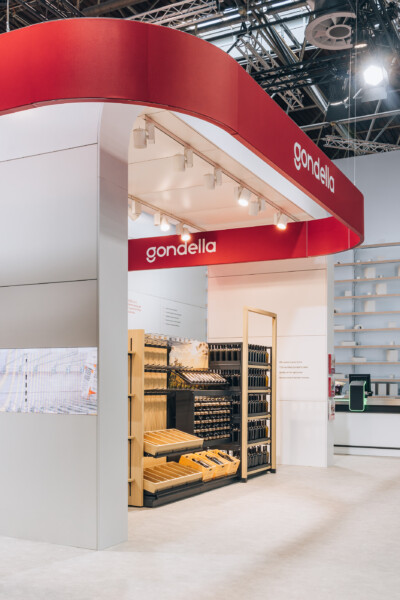 Gondella retail shelving display booth at Euroshop 2023, featuring wooden and black metal storage units with product displays