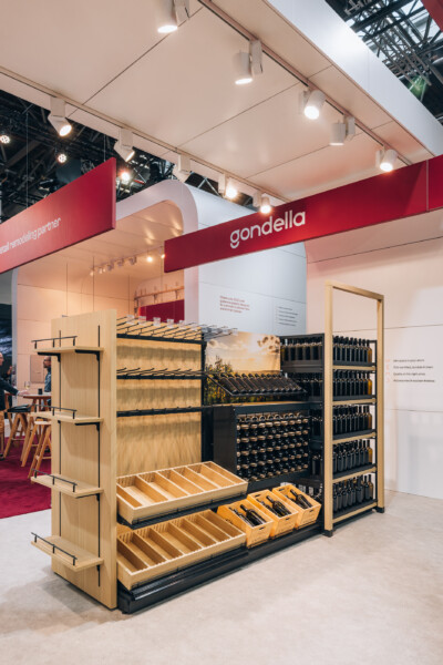 Gondella retail display booth at Euroshop 2023 featuring Pitch shelving with wooden frames, black metal fixtures, and product samples arranged in tiered drawers