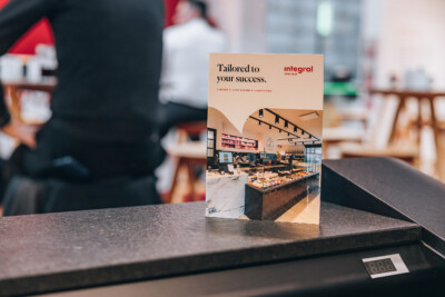 Integral Intérieur branding material displayed at Euroshop 2023, showing butcher shop design with modern counter display and pendant lighting