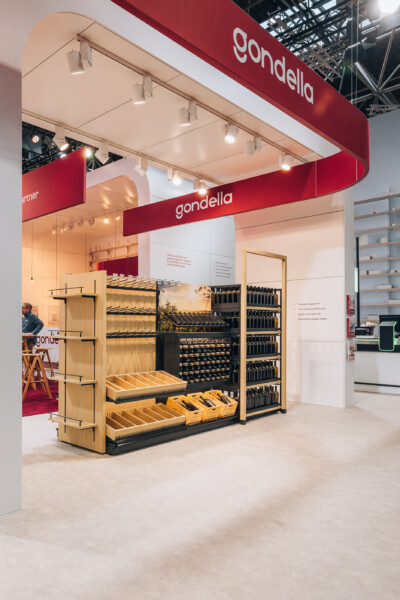 Gondella retail fixture display with Pitch shelving, wooden cabinetry, and black metal racks showcasing wine bottles and products at Euroshop 2023