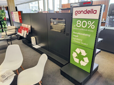 Gondella black retail display with integrated oven, green panel highlighting 80% recycled material content and recycling symbol, showroom setting