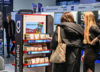 Gondella retail display stand with protein brownie products at trade show, featuring red shelves and pricing signage