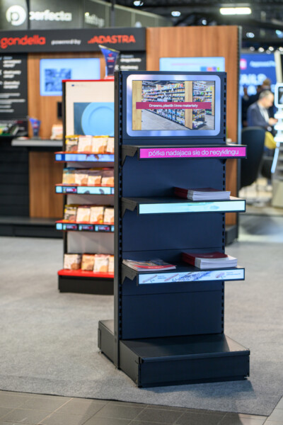 Gondola display unit with digital screen showing retail shelf signage at retail trade show
