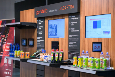 Gondella retail display booth at Warsaw trade show featuring Pitch shelving, checkout counter, digital screens, and product demonstrations
