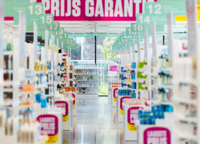 Retail store interior with Pitch shelving system displaying groceries and beverages under price guarantee signage
