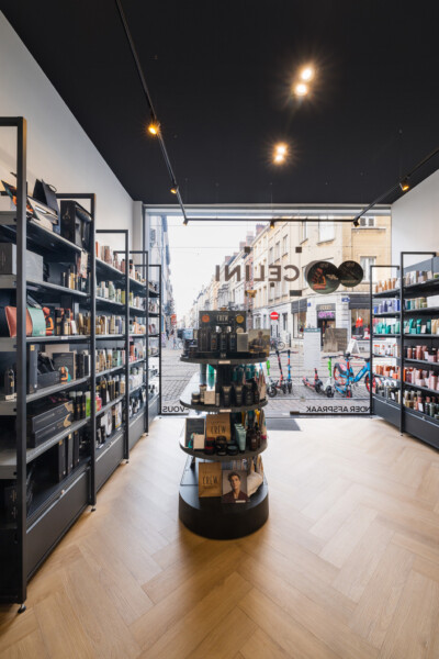 American Crew retail store interior with Pitch shelving, central display tower, and street-level storefront view in Brussels