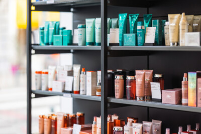 Kérastase beauty products displayed on black shelving with turquoise and bronze packaging in tiered arrangement