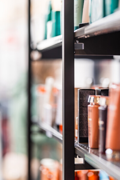 Gondella shelving display with beauty and personal care products in orange and teal bottles