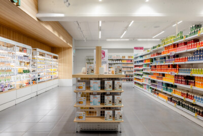 Medi-Market pharmacy store interior with Pitch 25 shelving displaying health and beauty products, central gondola display, and checkout counter