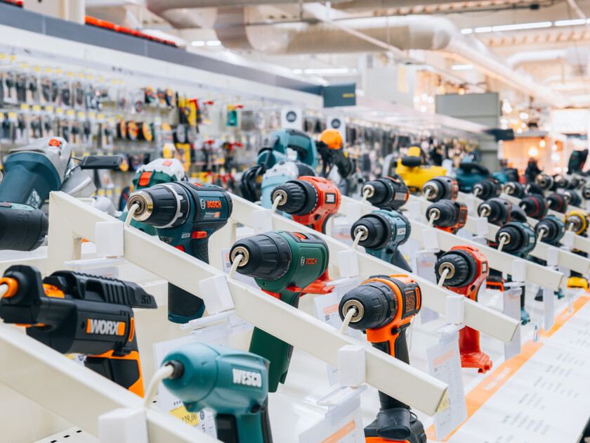 Bosch power drills and impact drivers displayed on white retail shelving in hardware store showroom