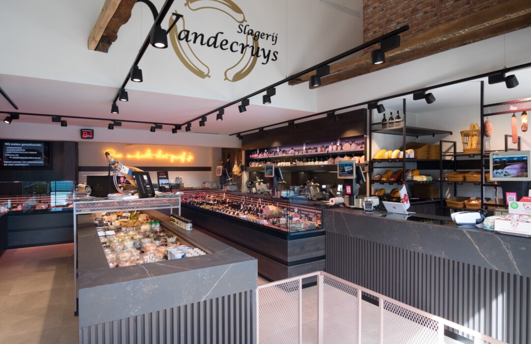 Stagery Vandecruys specialty food deli counter with tiered shelving, refrigerated displays, and product merchandising