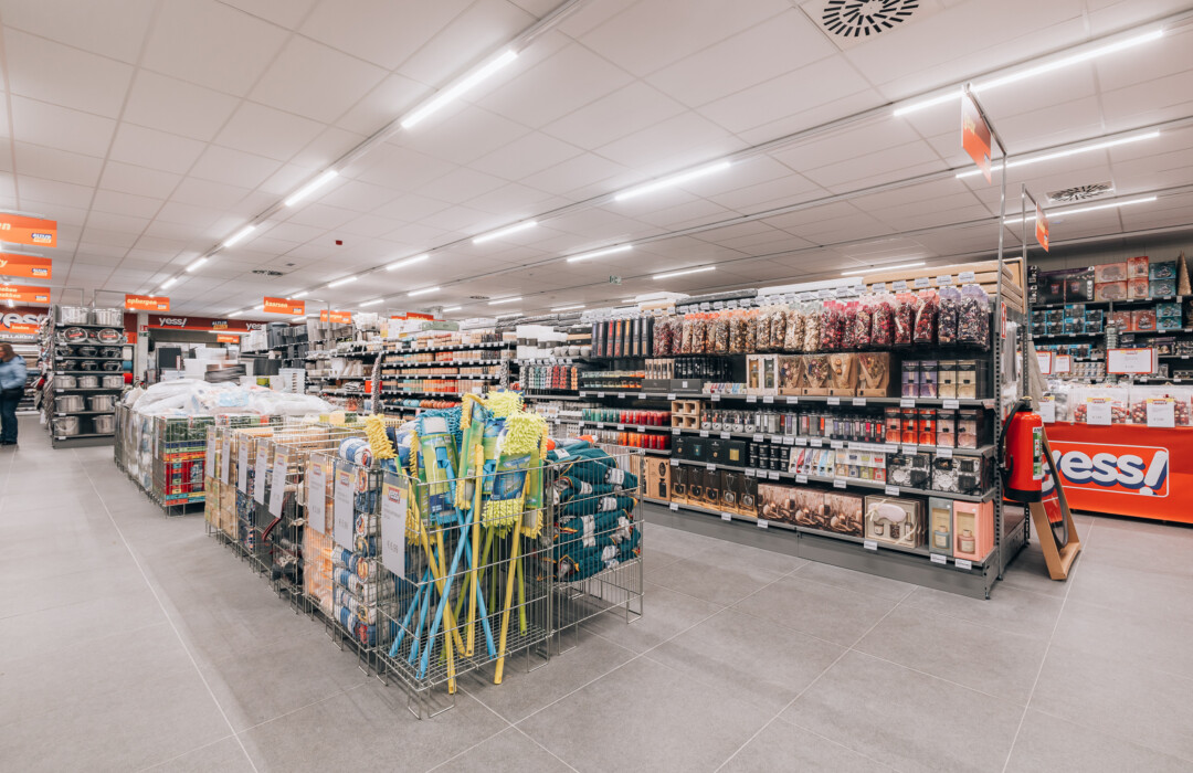 Yess supermarket interior with Pitch shelving displaying household products, beauty items, and packaged goods across multiple aisles