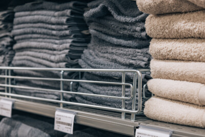 Folded towels and textiles displayed on retail shelving with divider in fashion or home goods store