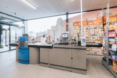Yess supermarket checkout counter with Gondella shelving display and product wall featuring orange price signage