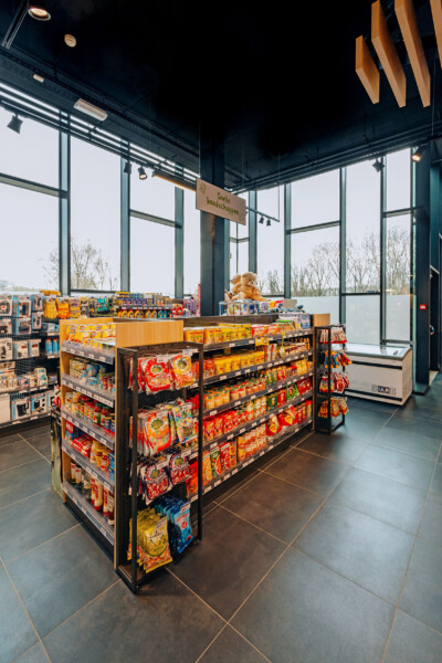 Pitch 25 shelving with yellow and red packaged goods display in modern retail space with floor-to-ceiling windows
