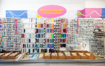 Health & beauty retail display with colorful pegboard shelving holding hair accessories, tools, and small packaged items in wicker baskets below
