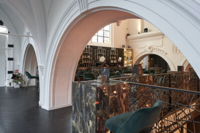 Holy Food Market horeca interior with Gondella custom curved archway, dark marble counter, and shelving display