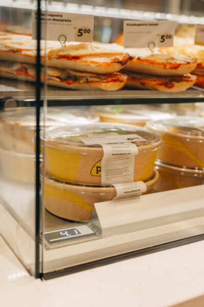 Heated display case with sandwich baguettes and prepared food items in specialty food retail setting