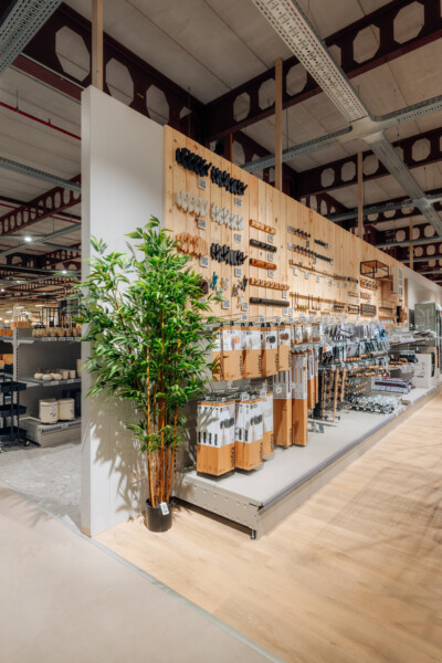 Pitch 25 shelving system with wooden pegboard wall displays, retail hardware fixtures, and packaged products on white platform in modern showroom