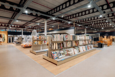 Retail showroom display with Pitch shelving, wallpaper samples, furniture, and home decor products in warehouse setting