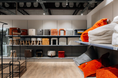 Pitch 25 shelving display with home textiles, bedding, and cushions in neutral and orange tones