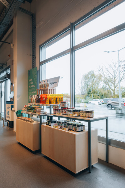 Pitch shelving display with packaged food products and signage in retail store with large windows