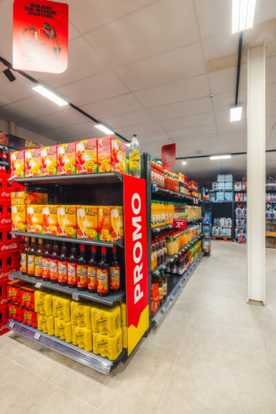 Promo beverage display with Pitch shelving showcasing juice and soft drinks in Carrefour Market supermarket