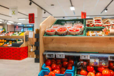 Pitch 25 shelving with fresh tomatoes in blue crates and packaged produce in wooden display at Carrefour Market supermarket