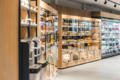 Carrefour Market Sint Jozef Brugge retail shelving display with wooden gondola units and glass-fronted cases