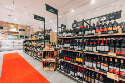 Delhaize wine and spirits section with Pitch shelving displaying Italian wines and Faustino bottles