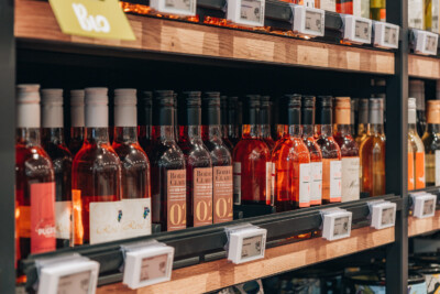 Wine shelf display with Bordeaux bottles and rosé wines in specialty food retail environment