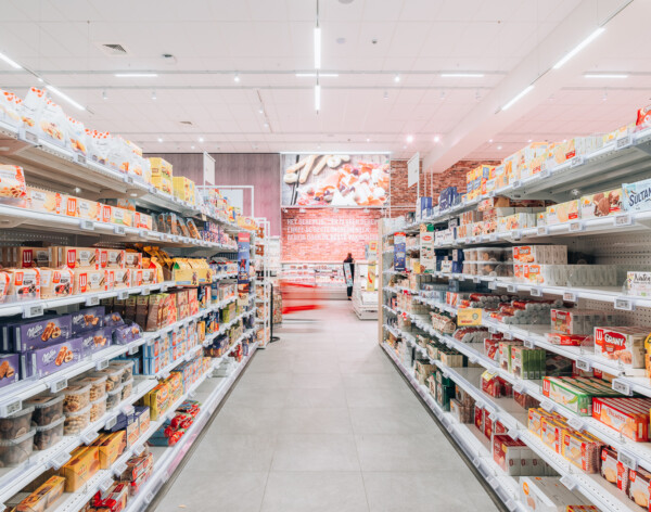 Refrigerated shelving displaying packaged food products in a supermarket aisle with LED lighting