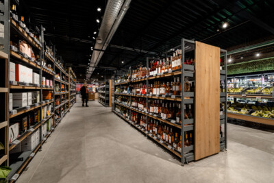Liquor section with Pitch 25 wooden shelving displaying spirits bottles in supermarket retail environment