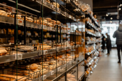 Pitch 25 shelving with fresh bread and bakery products displayed in metal baskets, Delhaize supermarket