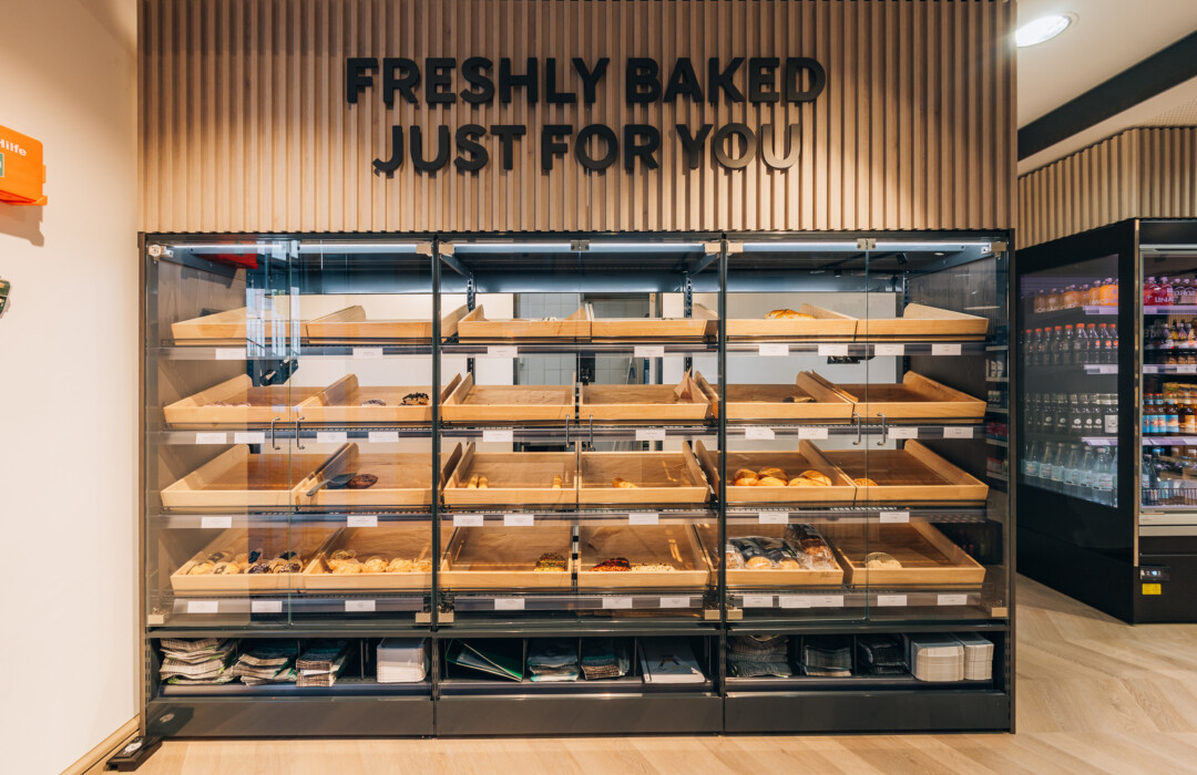 Pitch 25 shelving display with freshly baked goods in wooden trays, bakery retail fixture with glass doors