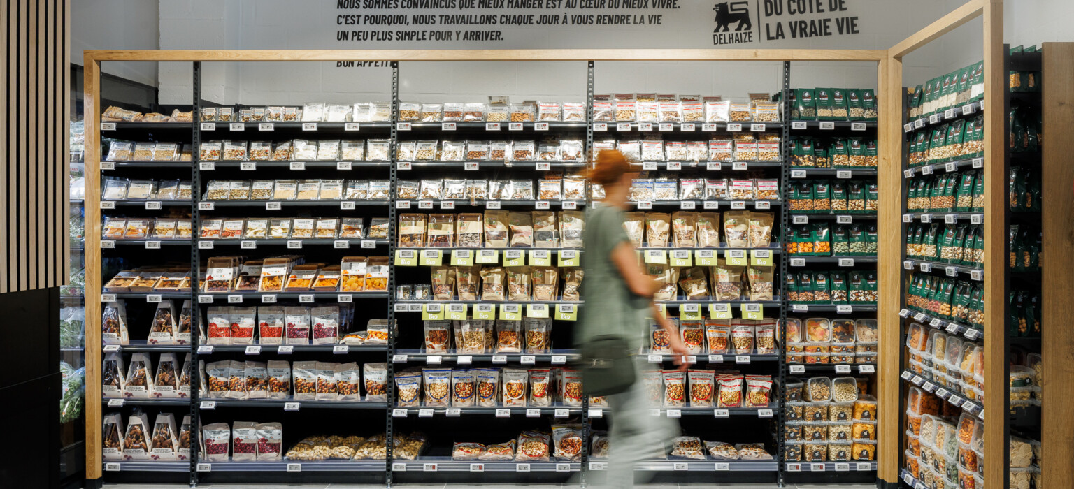 Delhaize supermarket bulk foods section with Gondella black shelving displaying cereals, grains, and legumes in clear containers