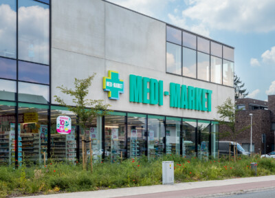 Medi-Market pharmacy storefront with Pitch 25 shelving displaying health and beauty products behind glass windows