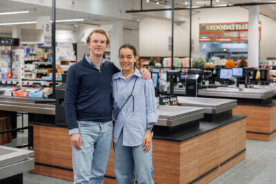Delhaize supermarket checkout counter with staff in modern retail environment