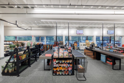 Delhaize supermarket checkout area with Pitch shelving, product displays and numbered checkout lanes 5-8