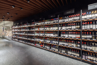 Pitch 41 wine shelving display in Delhaize supermarket with red-capped bottles organized by region