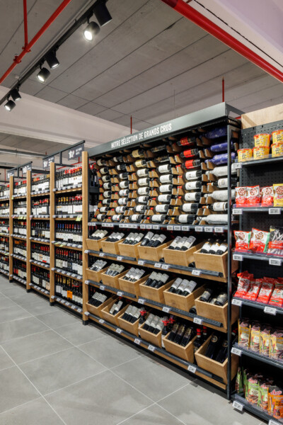 Delhaize wine section with Pitch 41 shelving displaying grands crus bottles and wooden display bins