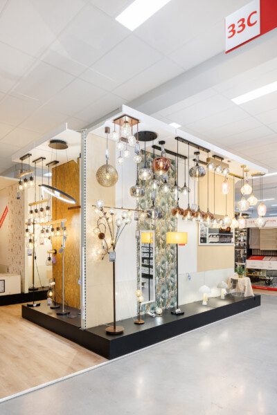 Lighting display showroom with pendant lights, floor lamps and wall-mounted fixtures in gold, copper and glass finishes