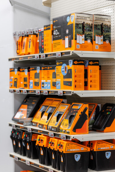 Gallagher electric fence energizer and battery products displayed on retail shelving in hardware store